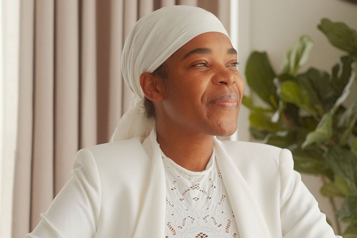 An image of the author, who has her hair in a white wrap, and is looking at the camera, smiling.